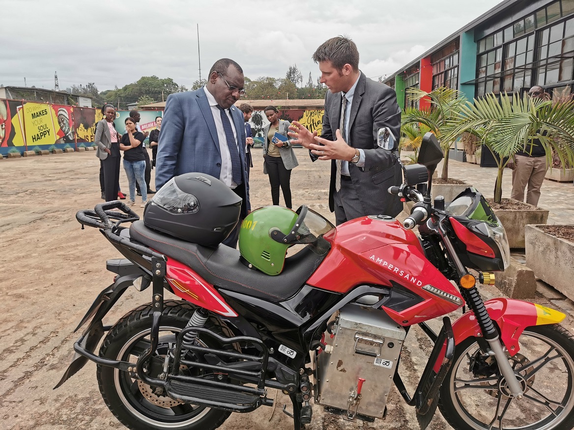 e-mobility in Africa using Ampersand electric motocyles man explain technology to another man showing the motorcycle