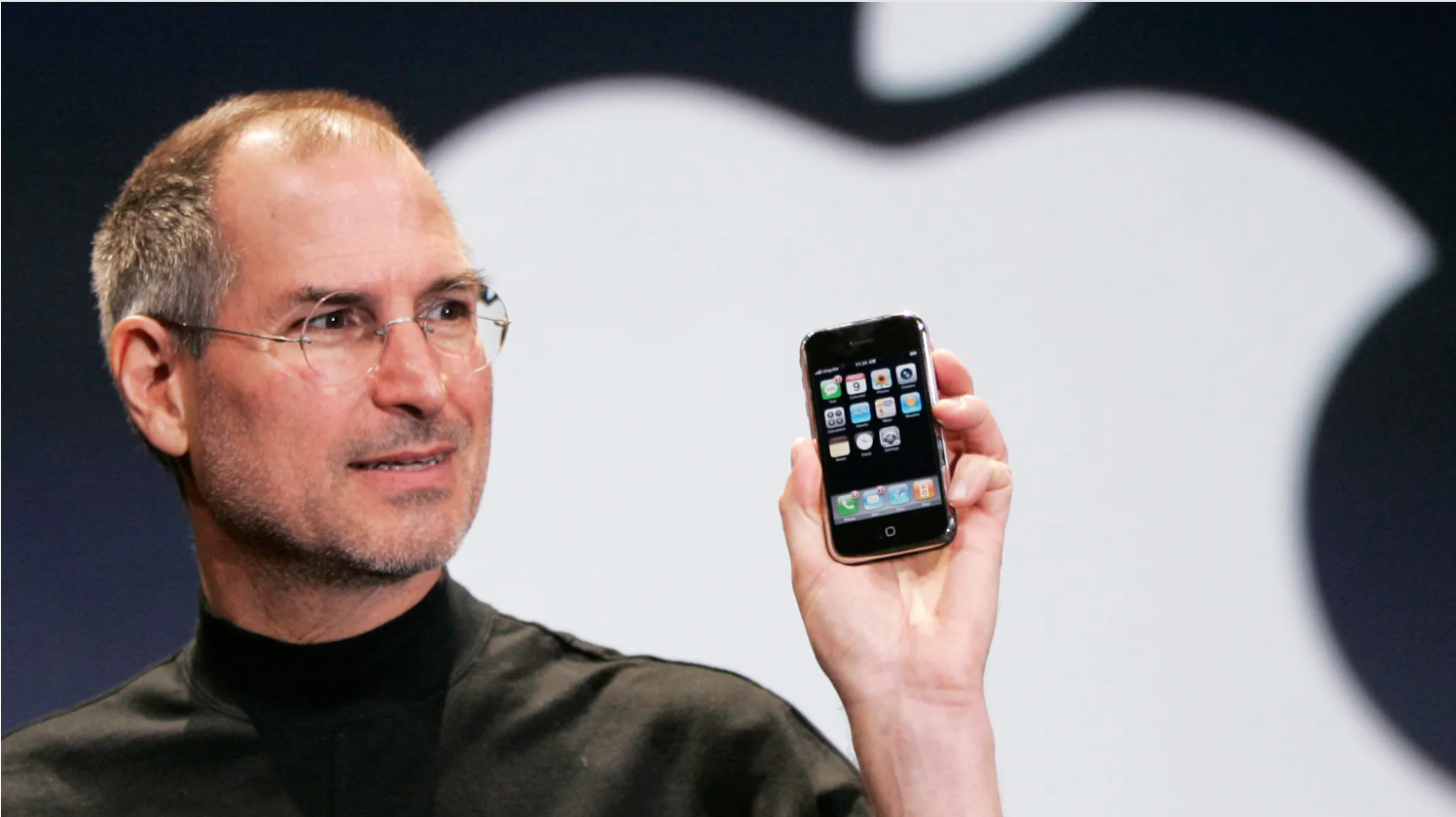 Former Apple CEO Steve Jobs holds up the first iPhone at MacWorld